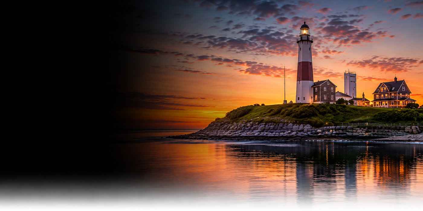 Lighthouse on a rocky island with a colorful sunset sky